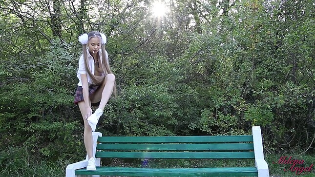 Student undresses on a bench in the park